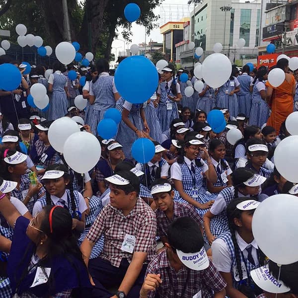 Students with blue and white balloons at the start of the Buddy March