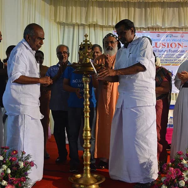 Guests on stage beside the ceremonial lamp