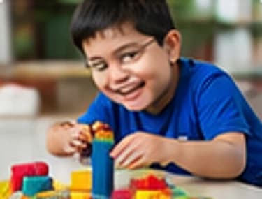 A boy building a tower with colourful blocks