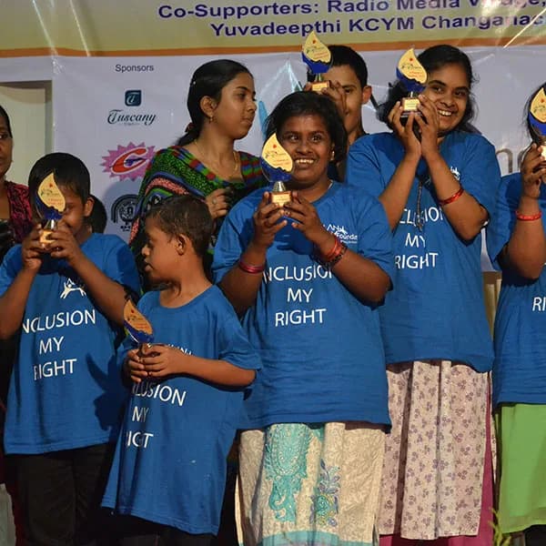 Young people in ‘Inclusion My Right’ T-shirts holding their awards